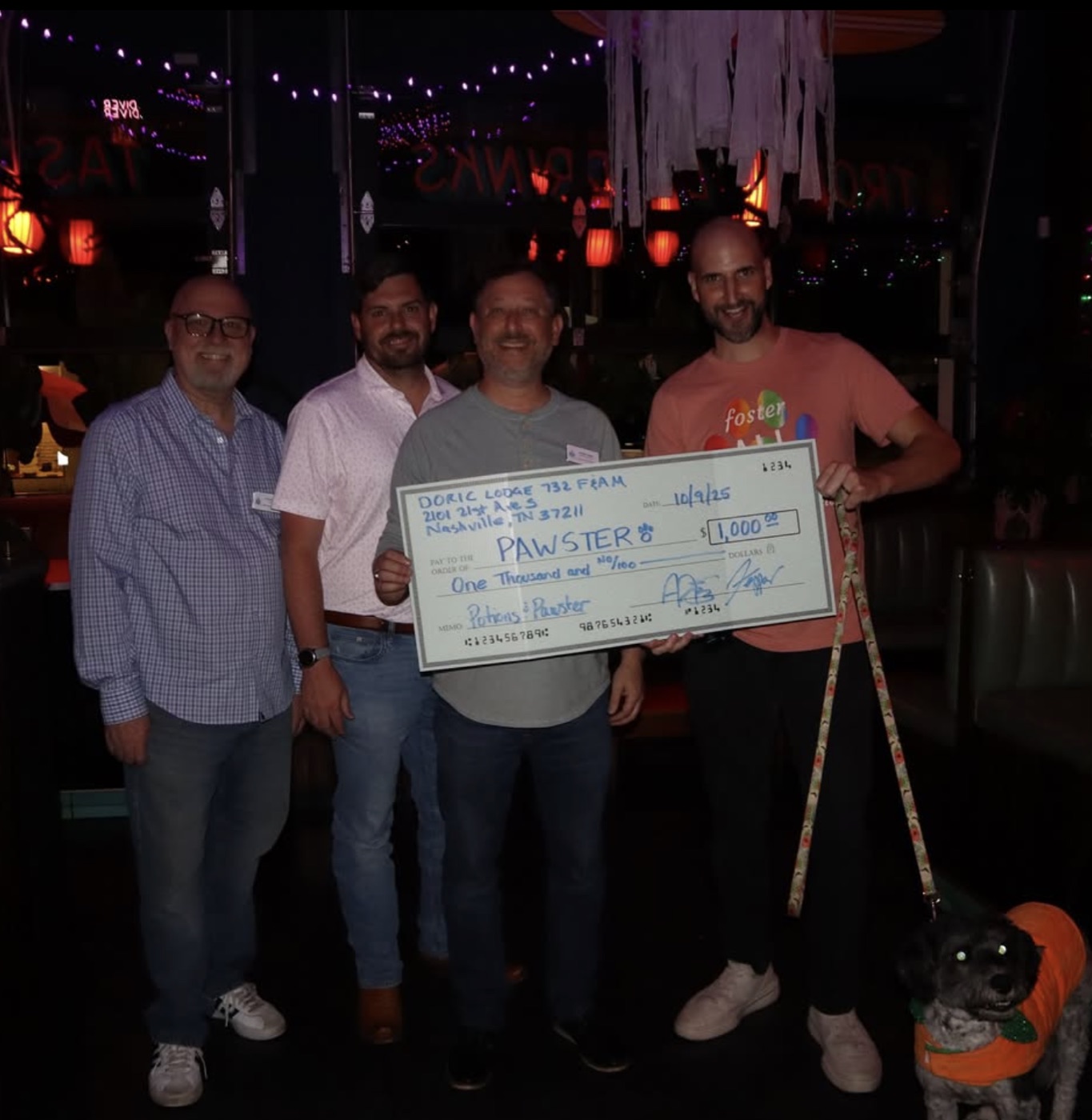 Doric Lodge presenting Pawster with a $1,000 check at Potions and Paws