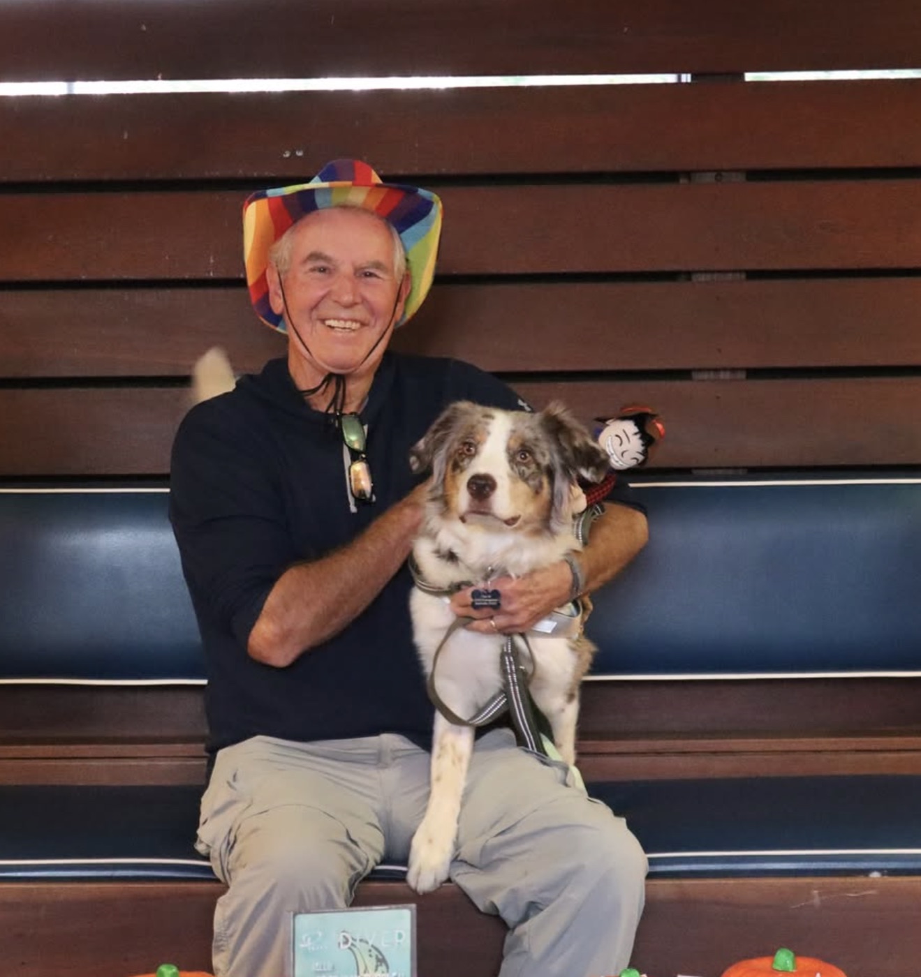 Guest with his dog wearing a rainbow hat