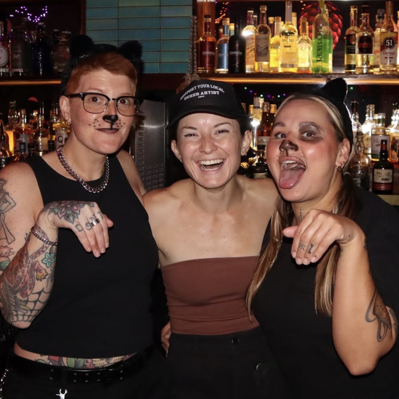 Bartenders in cat and dog face paint behind the bar